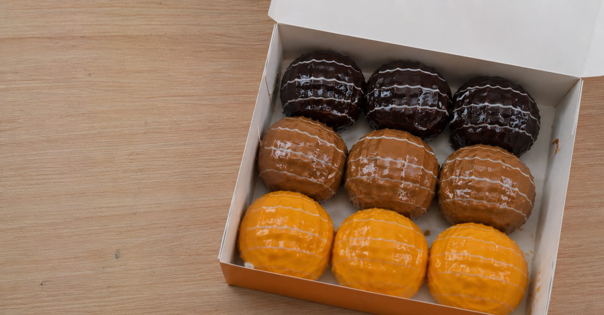 Kotak Donat Pops berisi donat glazed, cokelat, dan karamel